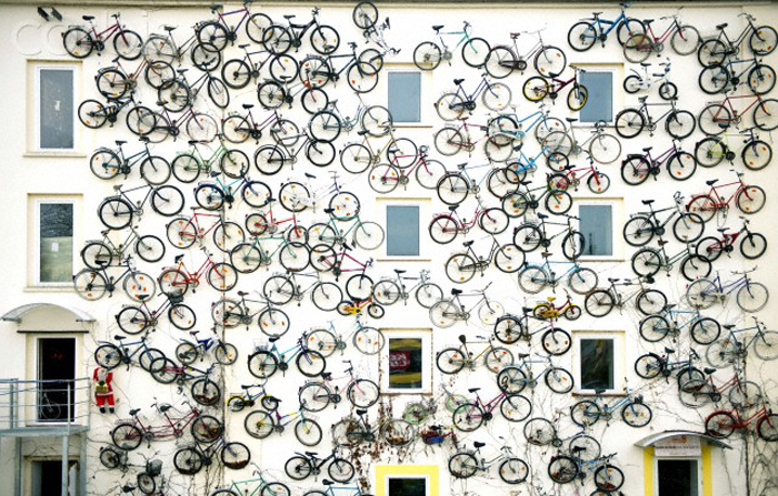 12 Sep 2013, Berlin, Germany --- Altlandsberg, Germany. 12th September 2013 -- Store co-owner Christian Peterson stands next to the wall of bikes. -- Bike shop in Altlandsberg (Near Berlin), Germany, has the facade of their store covered with 120 bikes. --- Image by © GonÁalo Silva/Demotix/Corbis