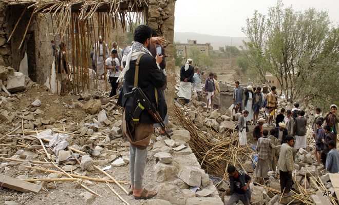 A Yemeni man uses his mobile to take photos of the rubble of houses destroyed by Saudi airstrikes in a village near Sanaa, Yemen, Saturday, April 4, 2015. Since their advance began last year, the Shiite rebels, known as Houthis have overrun Yemen's capital, Sanaa, and several provinces, forcing the country’s beleaguered President Abed Rabbo Mansour Hadi to flee the country. (AP Photo/Hani Mohammed)