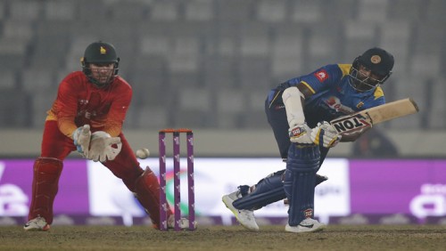 Sri Lanka's Thisara Perera, right, plays a shot, as Zimbabwe's wicketkeeper Brendan Taylor watches during the Tri-Nation one-day international cricket series in Dhaka, Bangladesh, Wednesday, Jan. 17, 2018. (AP Photo/A.M. Ahad)