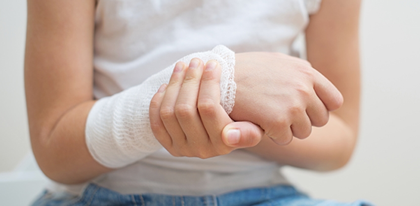 Child arm with gauze bandage on it.