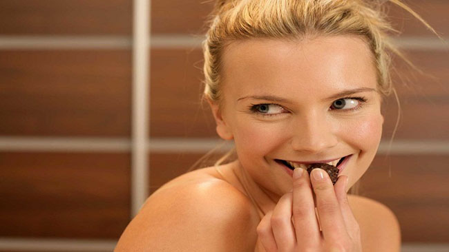 Young woman eating a praline